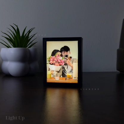 Display Mini, Framed lightbox with a photo of a couple with flowers on a dark surface, with 'Light Up' branding.